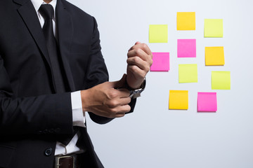 Businessman adjusting his costume on notepaper background