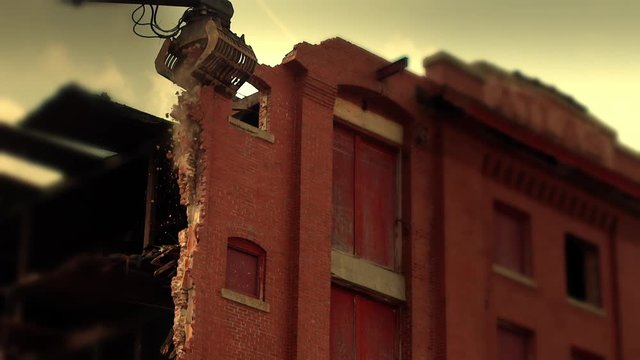 Zoom in shot of a mechanical claw breaking brick wall of a building