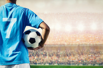 voetbalvoetballer in blauw teamconcept dat voetbalbal houdt