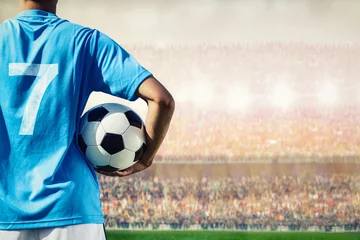 Tuinposter voetbalvoetballer in blauw teamconcept dat voetbalbal houdt © pixfly