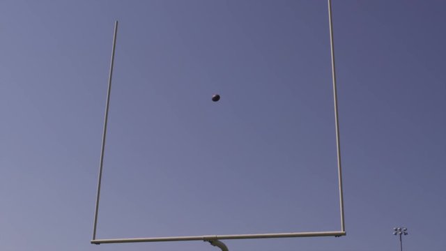 Slow motion, football field goal, blue screen.