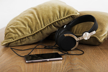 Headphones on cushions on a wooden surface
