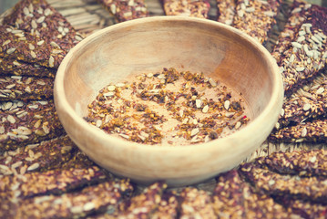 Slices or healthy, raw cereal crispy breads with nuts, seeds and spices on wooden board