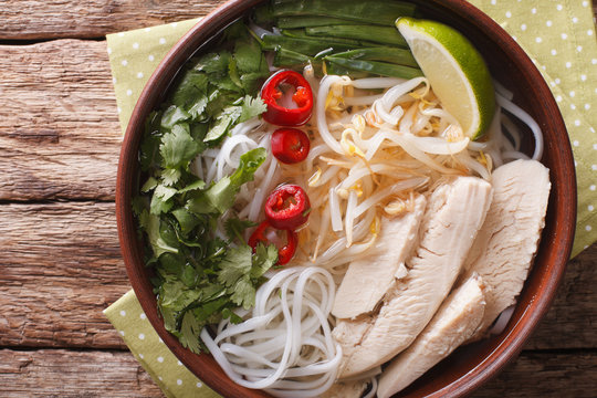 Vietnamese soup Pho Ga with chicken and rice noodles close-up. Horizontal top view