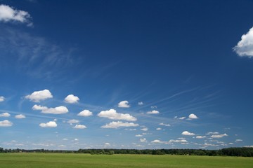 Obraz na płótnie Canvas blue sky with clouds over green field