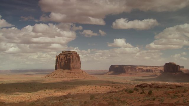 Wide shot of rock formation in monument valley against cloudy sky