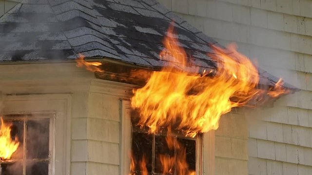 Tilt up of house window burning in fire