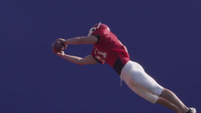 Football bluescreen, a football player catches a football.