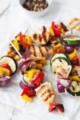 Closeup of chicken skewers or shashlik with grilled vegetables (mushrooms, paprika, salad, zucchini, onion)