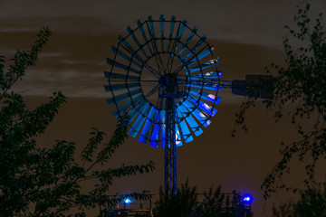 old illuminated wind wheel of illuminated industrial plant by night, duisburg