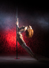 Fototapeta na wymiar Female striptease on the pole