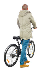 Obraz premium back view of a man with a bicycle. Cyclist in parka jacket keeps the wheel of a bicycle. Rear view people collection. backside view of person. Isolated over white background.