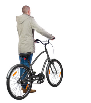 back view of a man with a bicycle. Cyclist in parka jacket keeps the wheel of a bicycle. Rear view people collection.  backside view of person. Isolated over white background.