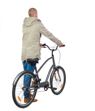 back view of a man with a bicycle. Cyclist in parka jacket keeps the wheel of a bicycle. Rear view people collection.  backside view of person. Isolated over white background.