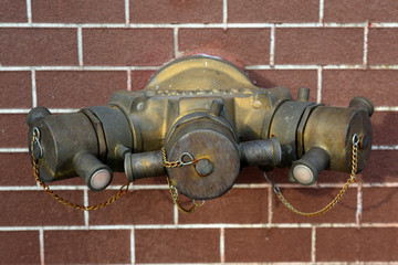 Hydrant with water hoses and fire extinguish equipment on brick