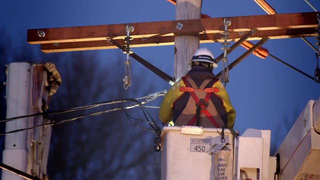 Close up of utility worker in cherry picker working on power line