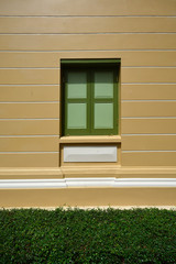 Wooden vintage window on color wall with green grass for backgro