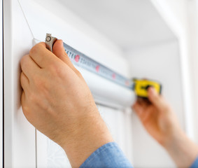 Man installing cassette roller blinds on windows.