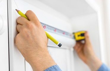 Man installing cassette roller blinds on windows.