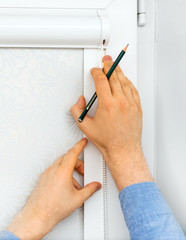 Man installing cassette roller blinds on windows.