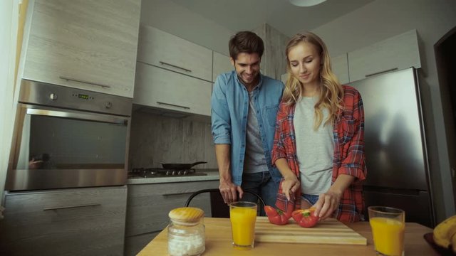 Couple cutting pepper.