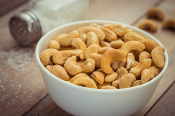 Cashew nuts in bowl and salt shaker, Filtered image