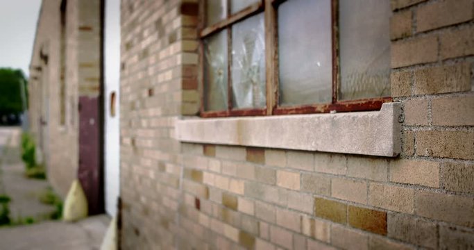 Close up of rundown brick wall and broken window