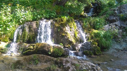 Fototapeta na wymiar Kleiner Wasserfall inmitten der Berge