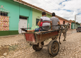 men on cart driving over the streets in trinidad, cuba