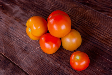 Close up view of fresh, ripe tomatoes on wood background.