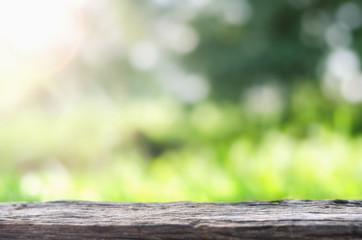 Empty wooden deck table over blurred tree with bokeh background