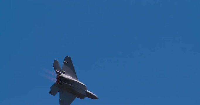 Tracking shot of military fighter jet flying in sky