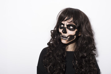 Portrait of woman with intimidating halloween makeup over black background looking left