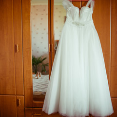 Magnificent dress hangs from a wooden wardrobe