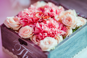 Pink flowers lie in a wooden box