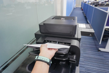 businesswoman wearing watch with paper sheet on printer tray