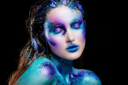 Portrait of a beautiful mermaid girl. Wet skin, wet hair, glitter and scales on his face. Blue eyes. The image on Halloween. Advertising Space.