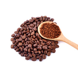 Coffee beans and ground coffee in a spoon.