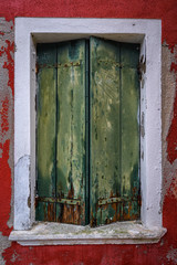 Shutters on window on red house in Burano, Italy