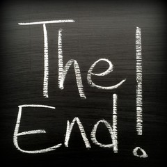 The phrase The End! written in white chalk on a blackboard. Vignette added for effect
