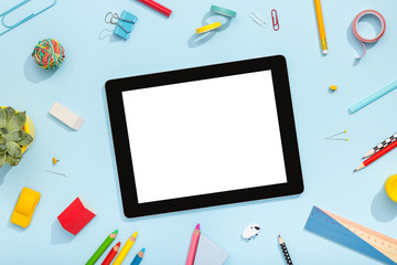 Back to school concept. Blank tablet with school and office supplies.