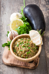 Baba ganoush and ingredients on wooden table

