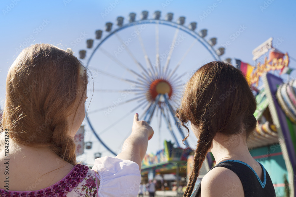 Wall mural German girls going to big ferris wheel at Oktoberfest