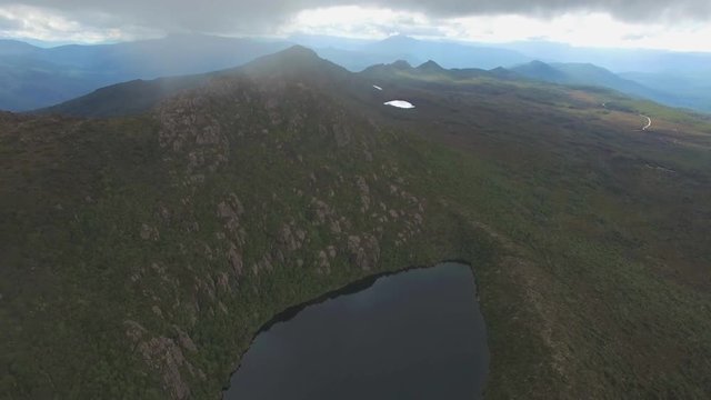 Backwards flight over Lake Esperance passing clouds at Hartz Mountains National Park, Tasmania, Australia
