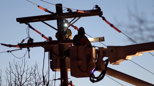 Close up of utility workers working on power line