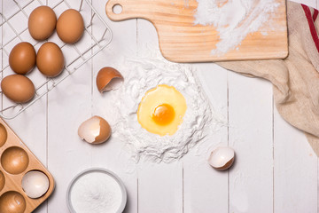 Egg in flour. Making dough background. Baking with raw eggs, sug