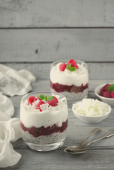 Healthy breakfast, desert, with chia seed pudding, cream, raspberry jam, coconut flakes and fresh berries
