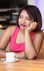 hispanic woman sitting at table and looking bored