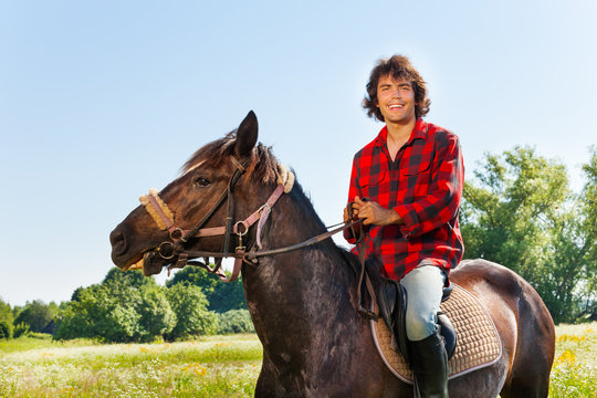 Portrait of happy equestrian riding his horse