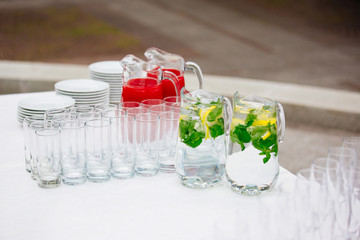The tradition of a summer drink Mojito with lime and mint and berry juice on a white table, wedding reception